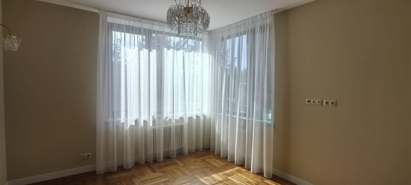 Светлая комната со шторами и местом за столом